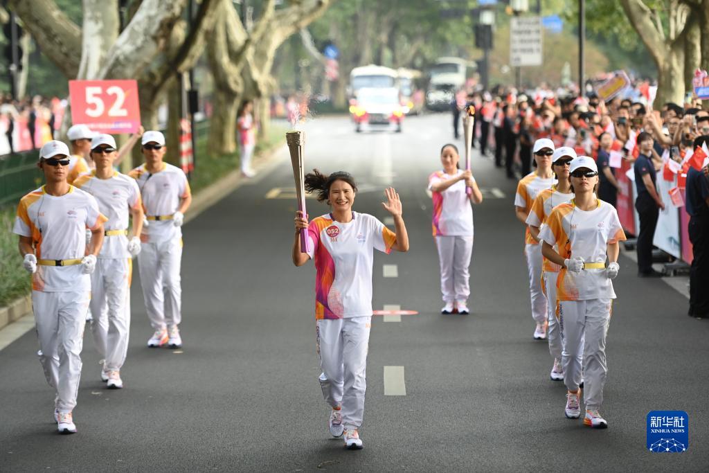 9月8日，杭州亚运会火炬传递在杭州西湖涌金公园广场启动，共有106棒火炬手参与当日传递。火炬手于姝珺（前）在火炬传递中。新华社记者 黄宗治 摄