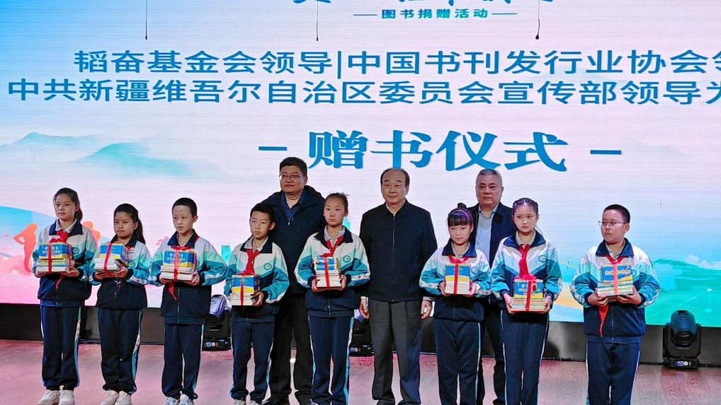 韬奋基金会、中国书刊发行业协会、中共新疆维吾尔自治区委员会宣传部印刷发行处领导为学生代表捐赠图书。主办方供图